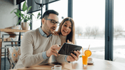 A couple choosing a wedding band online