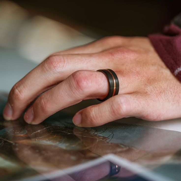 A polished black rhodium finish accented with a sleek gold-plated groove tungsten carbide ring