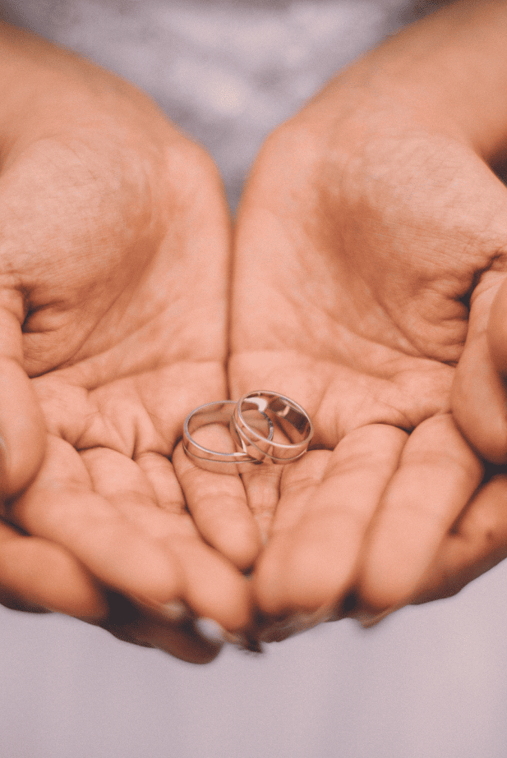 Couples holding wedding rings symbolizes love and commitment.