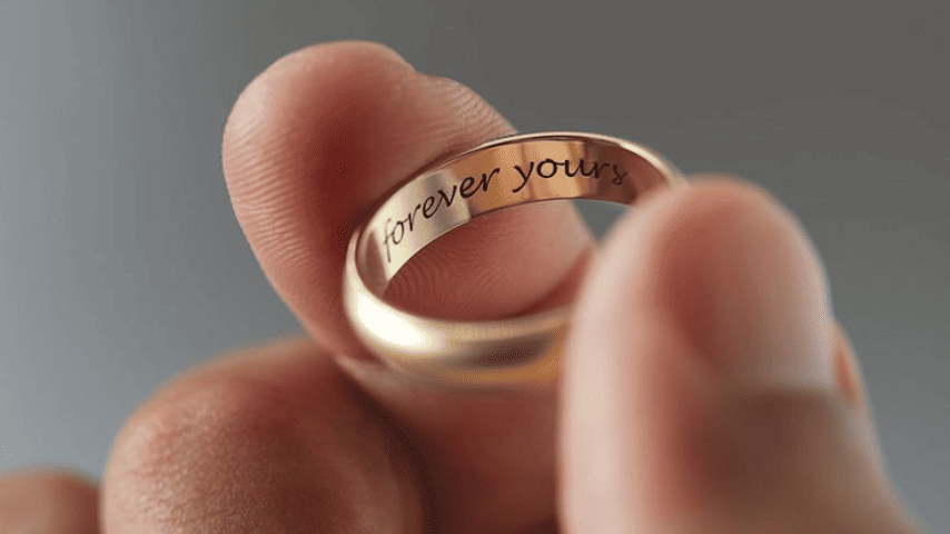 Engraved wedding ring says, "forever yours".